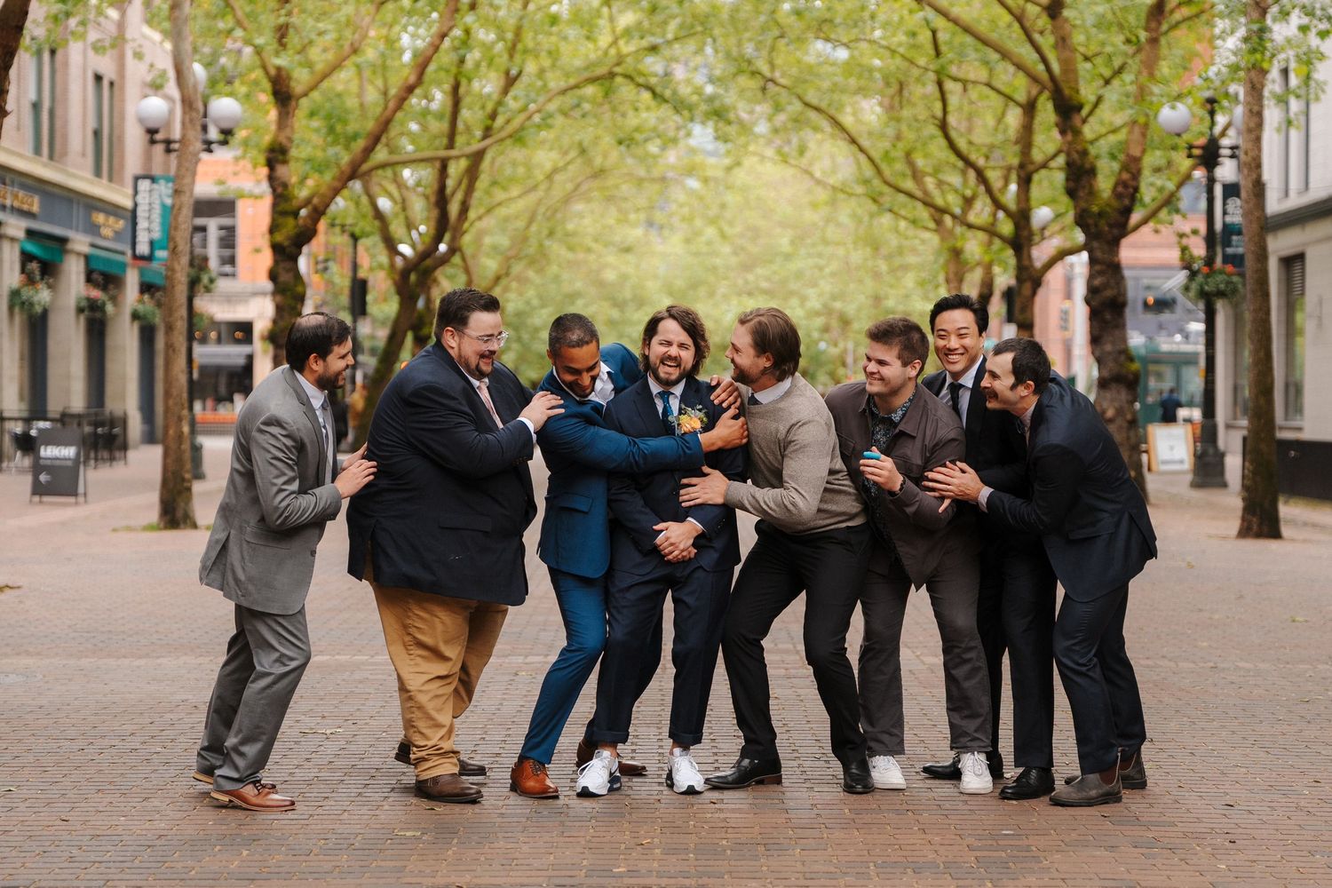 Ryker's groomsmen collapsing on him on for a funny photo at their 210 pioneer square wedding in Seattle.