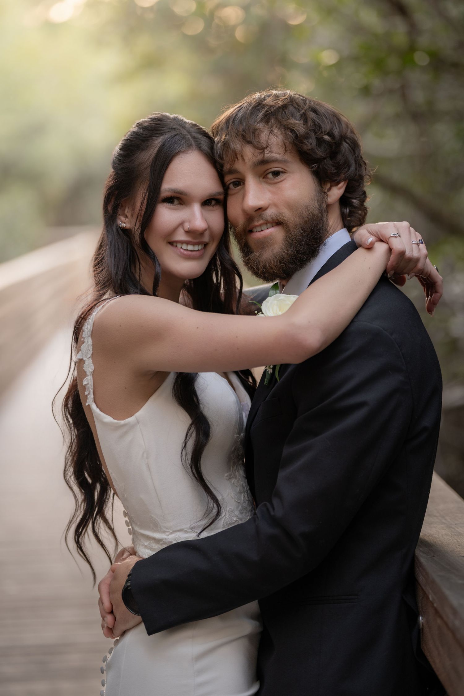 Bride and groom on the mangrove boardwalk with dappled light behind them at Indian Riverside Park