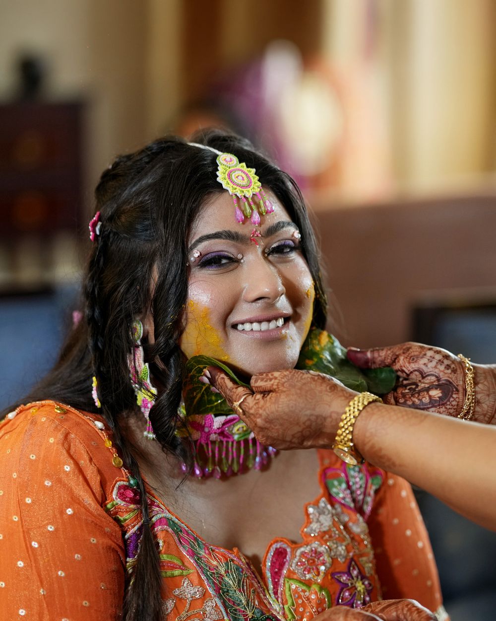 Indian bride smiling during Haldi ceremony.