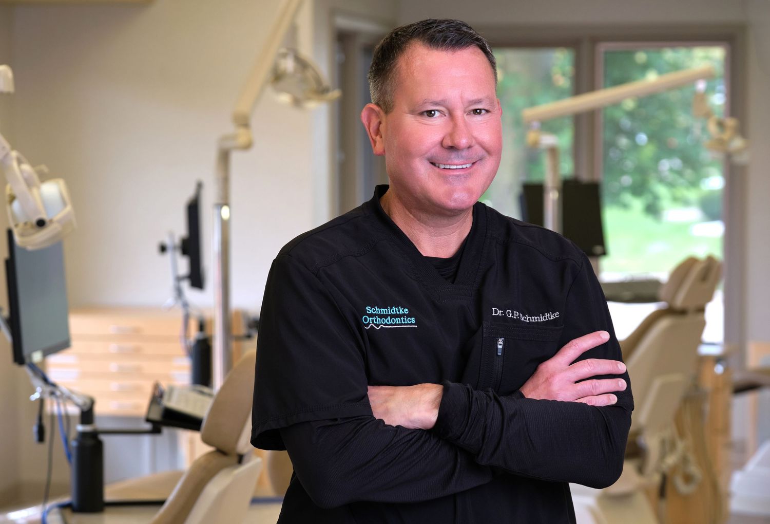 An orthodontist stands for a business headshot in his office in Appleton Wisconsin.