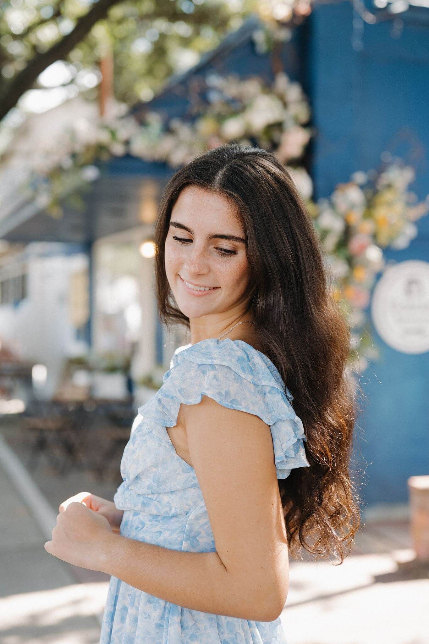 The Woodlands College Park School senior girl posing in front of a bake shop in Tomball Texas.