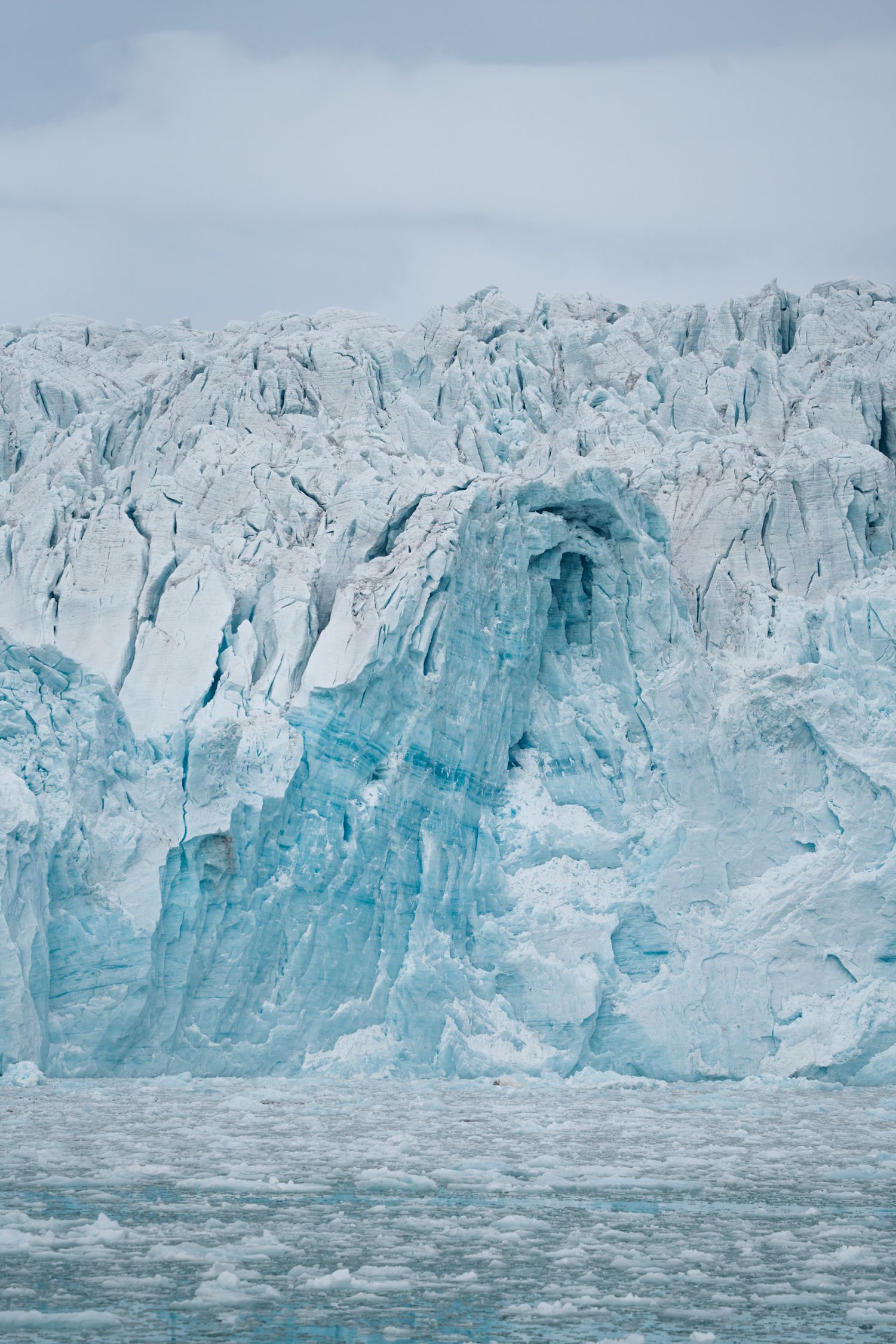 Langue de glace bleue striée descendant vers l'eau depuis un front glaciaire, glacier du 14 juillet