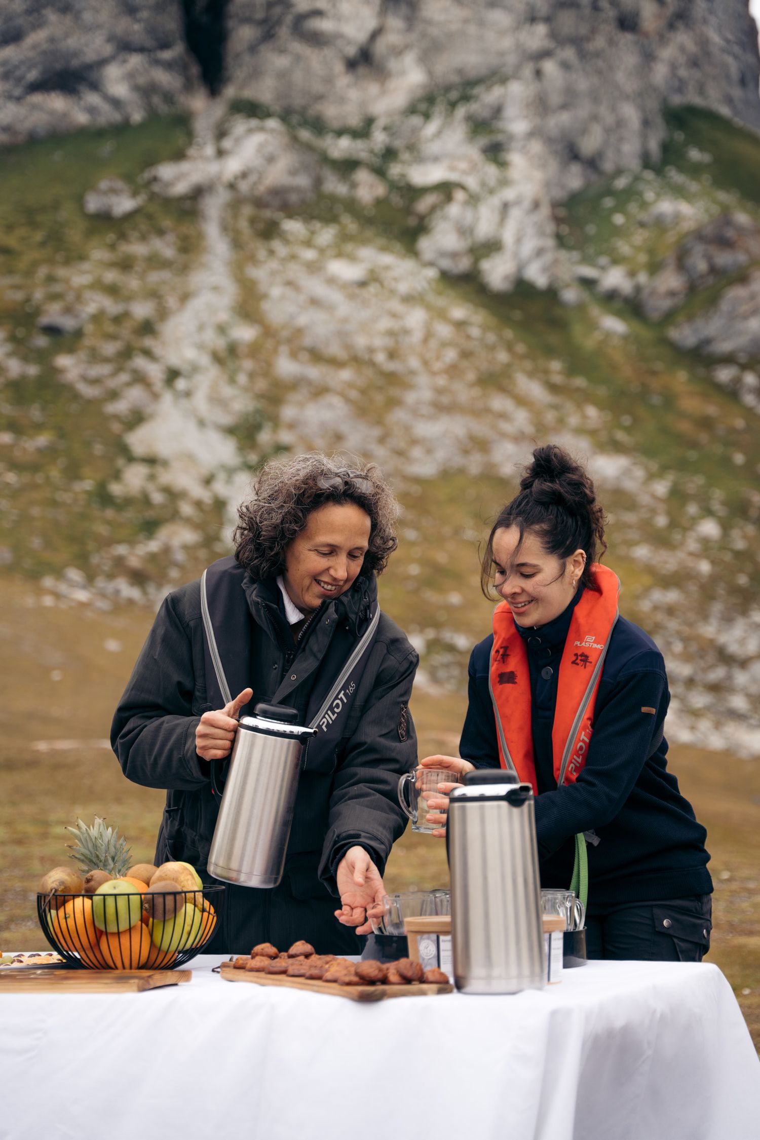 Membres d'équipage versant le chocolat chaud du goûter servi à terre, à Gnålloden