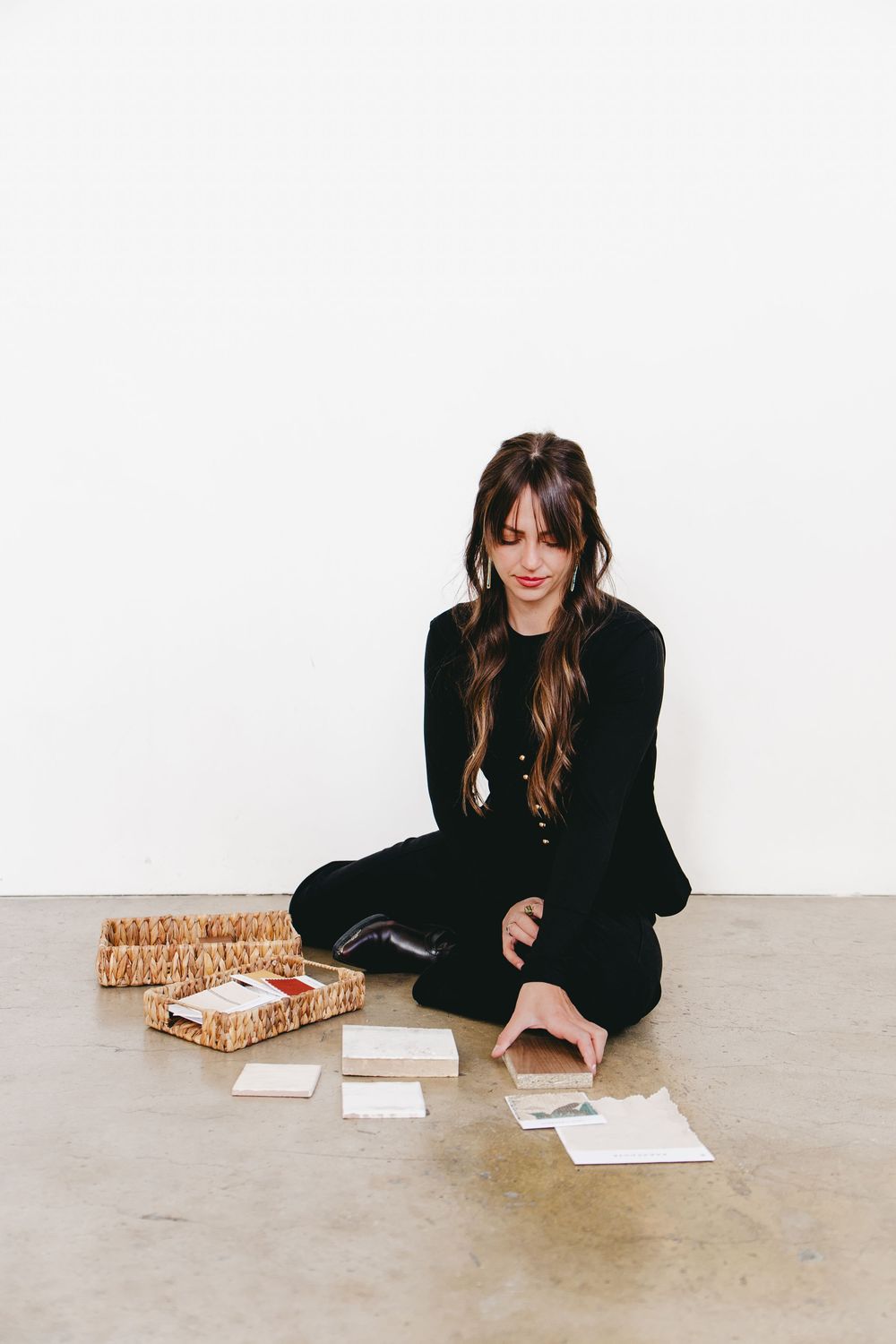 an interior designer laying tile samples in front of her on the floor