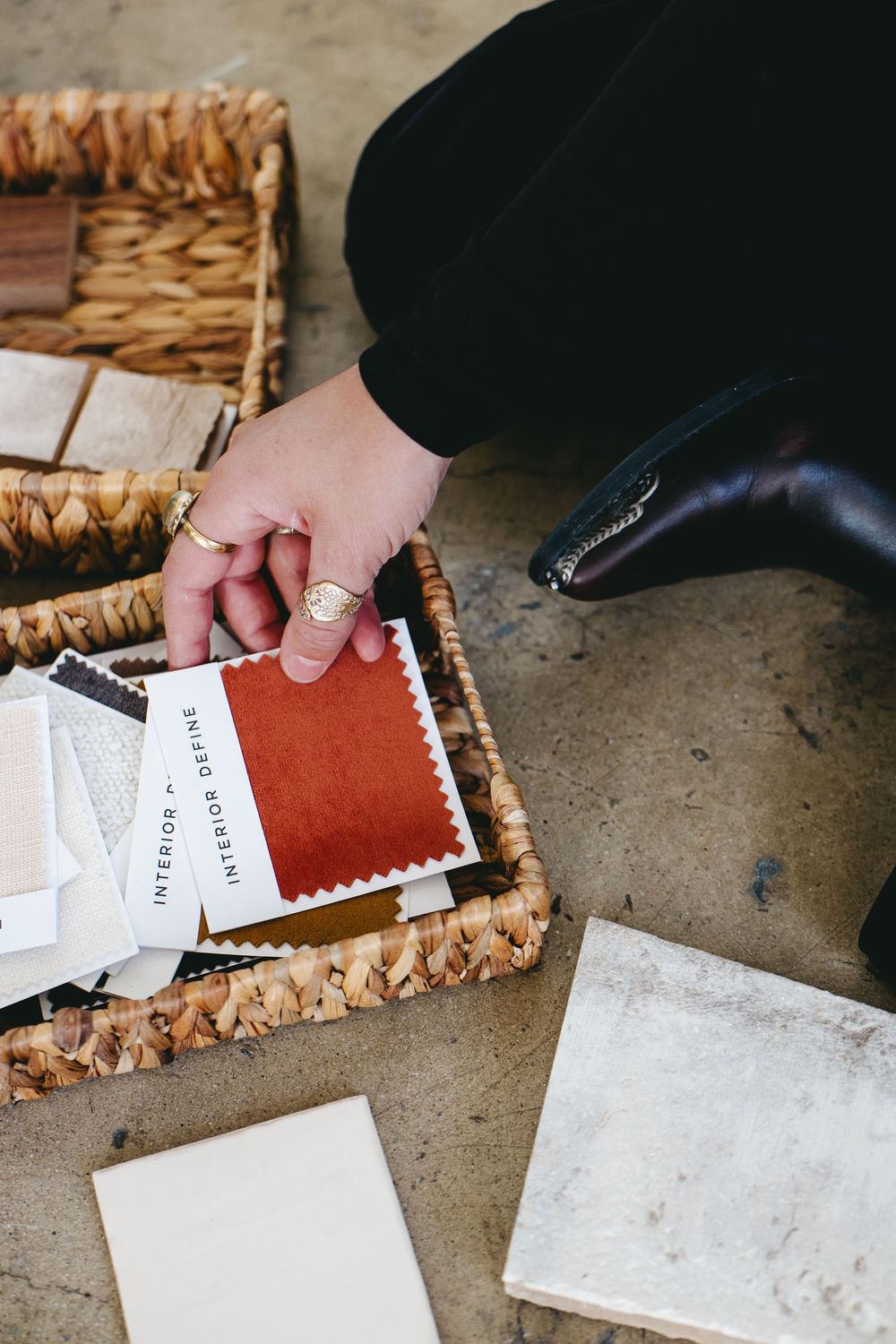 a woman wearing a silver ring picking up a fabric swatch