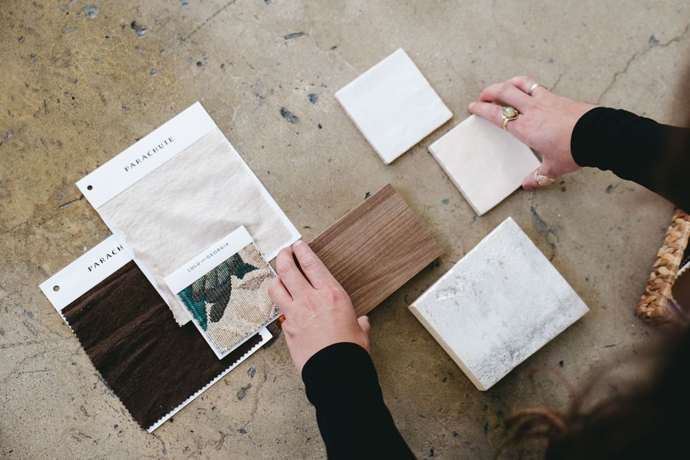 over the shoulder point of view of arranging interior design textiles