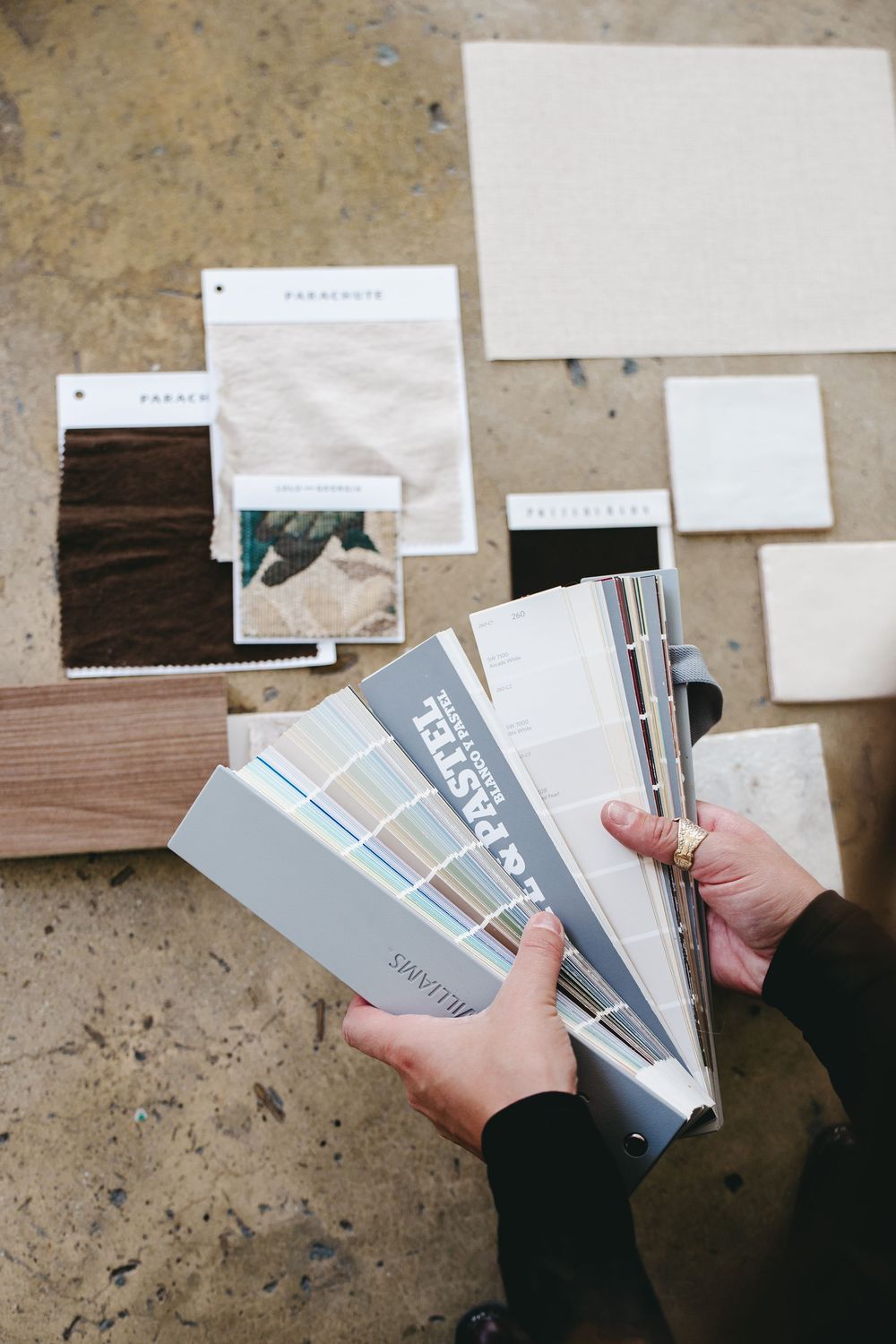 over the shoulder view of a woman flipping through paint swatches