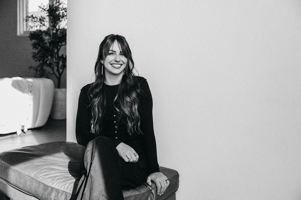 woman sitting on a leather ottoman edited in black and white