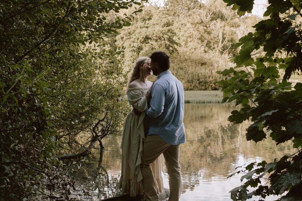 Couple standing together beside a lake during a relaxed photoshoot