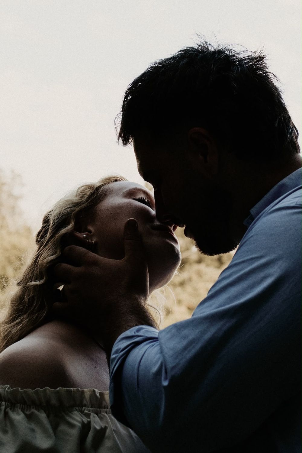 Close-up silhouette of a couple sharing a kiss at sunset