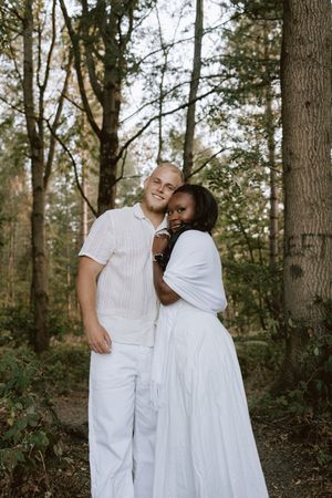 Couple smiling at camera in relaxed woodland photoshoot