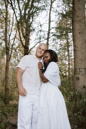 Couple smiling at camera in relaxed woodland photoshoot