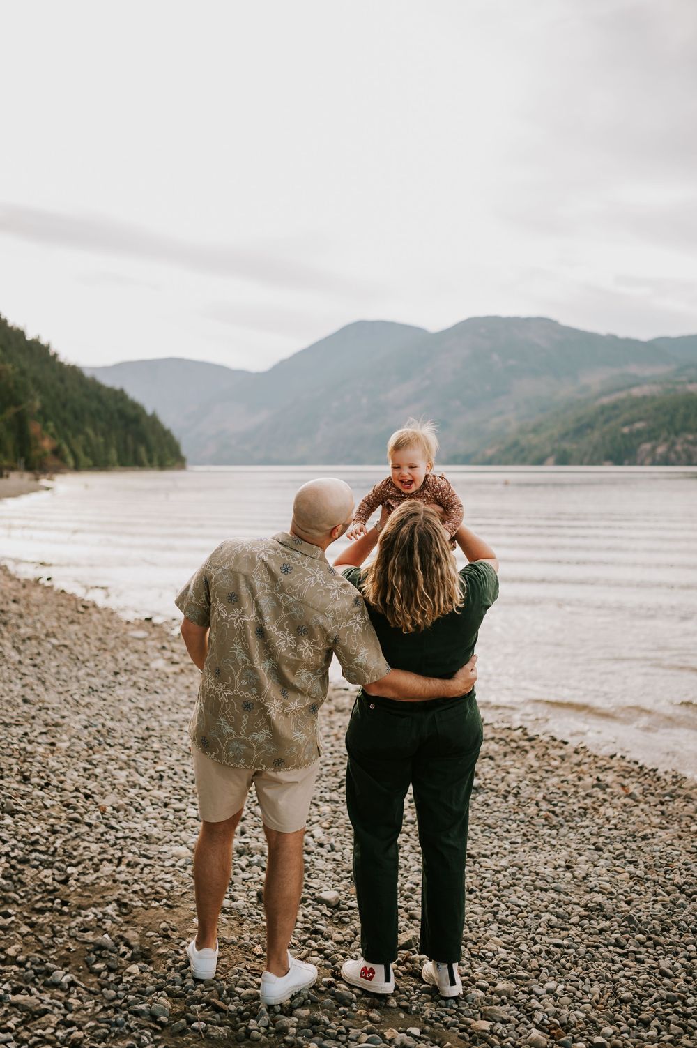 Comox Valley Photographer Portraits at Comox Lake in Cumberland, Vancouver Island. Casual and candid family photos parents holding baby
