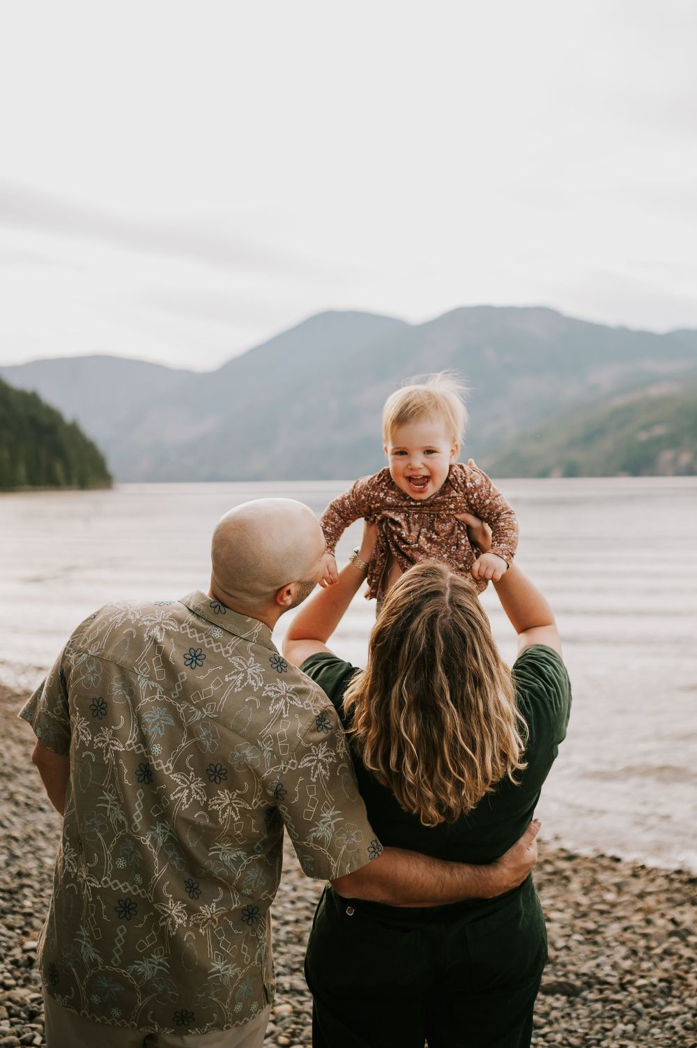 Comox Valley Photographer Portraits at Comox Lake in Cumberland, Vancouver Island. Casual and candid family photos parents holding baby