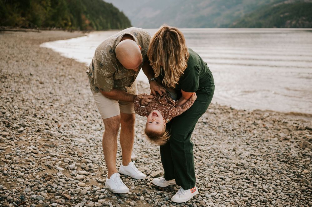Comox Valley Photographer Portraits at Comox Lake in Cumberland, Vancouver Island. Casual and candid family photos parents holding toddler