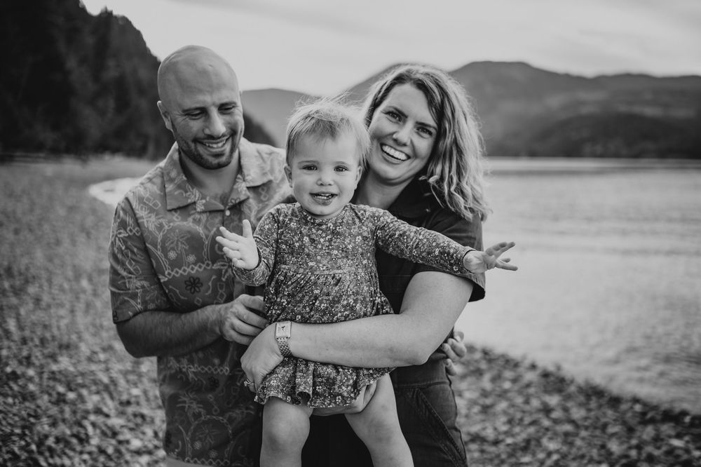 Comox Valley Photographer Portraits at Comox Lake in Cumberland, Vancouver Island. Casual and candid family photos parents holding toddler