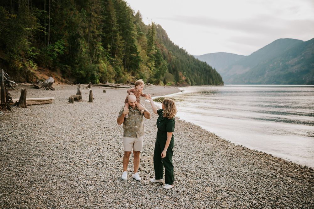 Comox Valley Photographer Portraits at Comox Lake in Cumberland, Vancouver Island. Casual and candid family photos parents holding baby