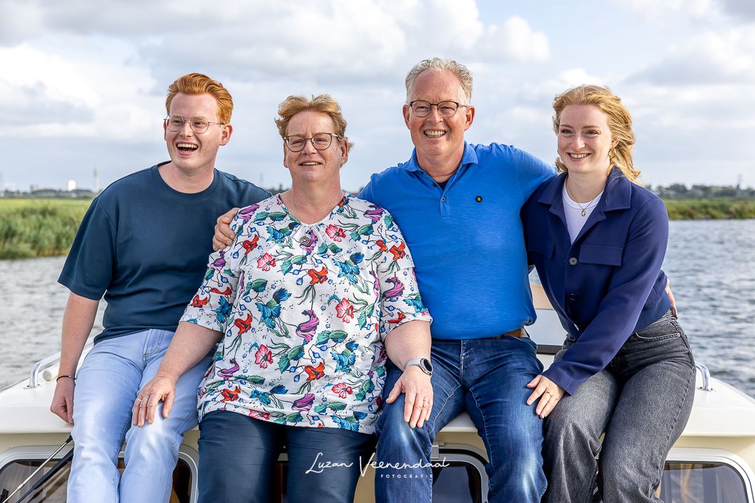 Gezin, vader, moeder, zoon en dochter, samen op het dak van de boot tijdens de familiefotoshoot in Uitgeest