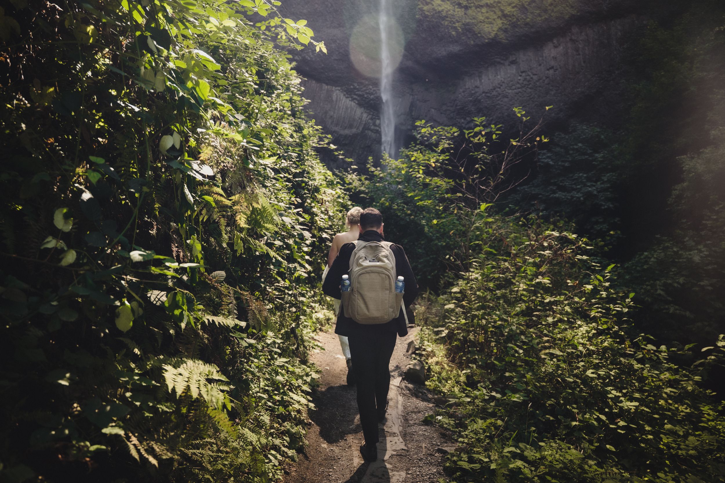 Eloping couple hikes down to an Oregon waterfall for dramatic photos