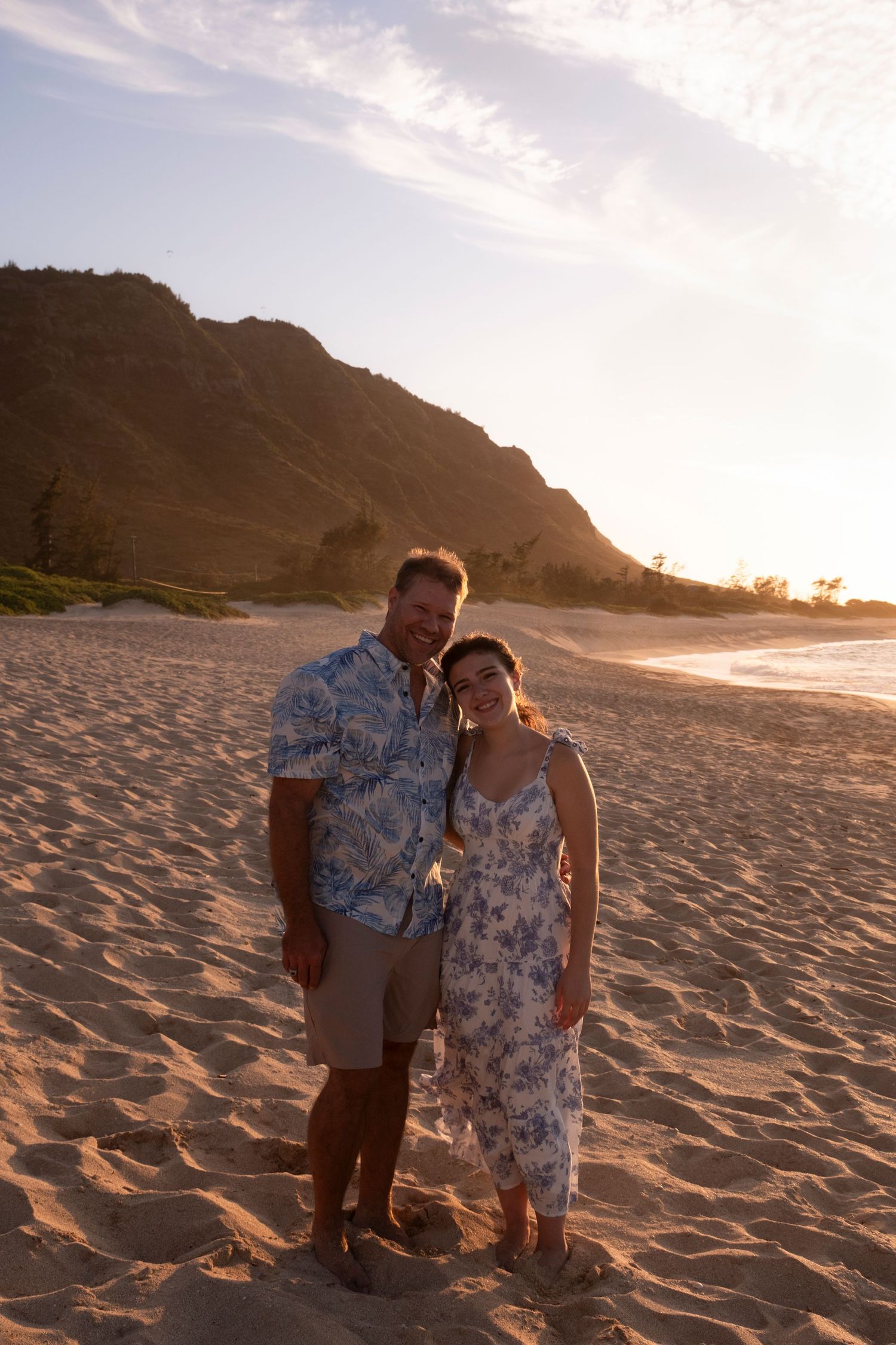 Father and daughter together on a North Shore Oahu beach in warm Hawaiian evening light