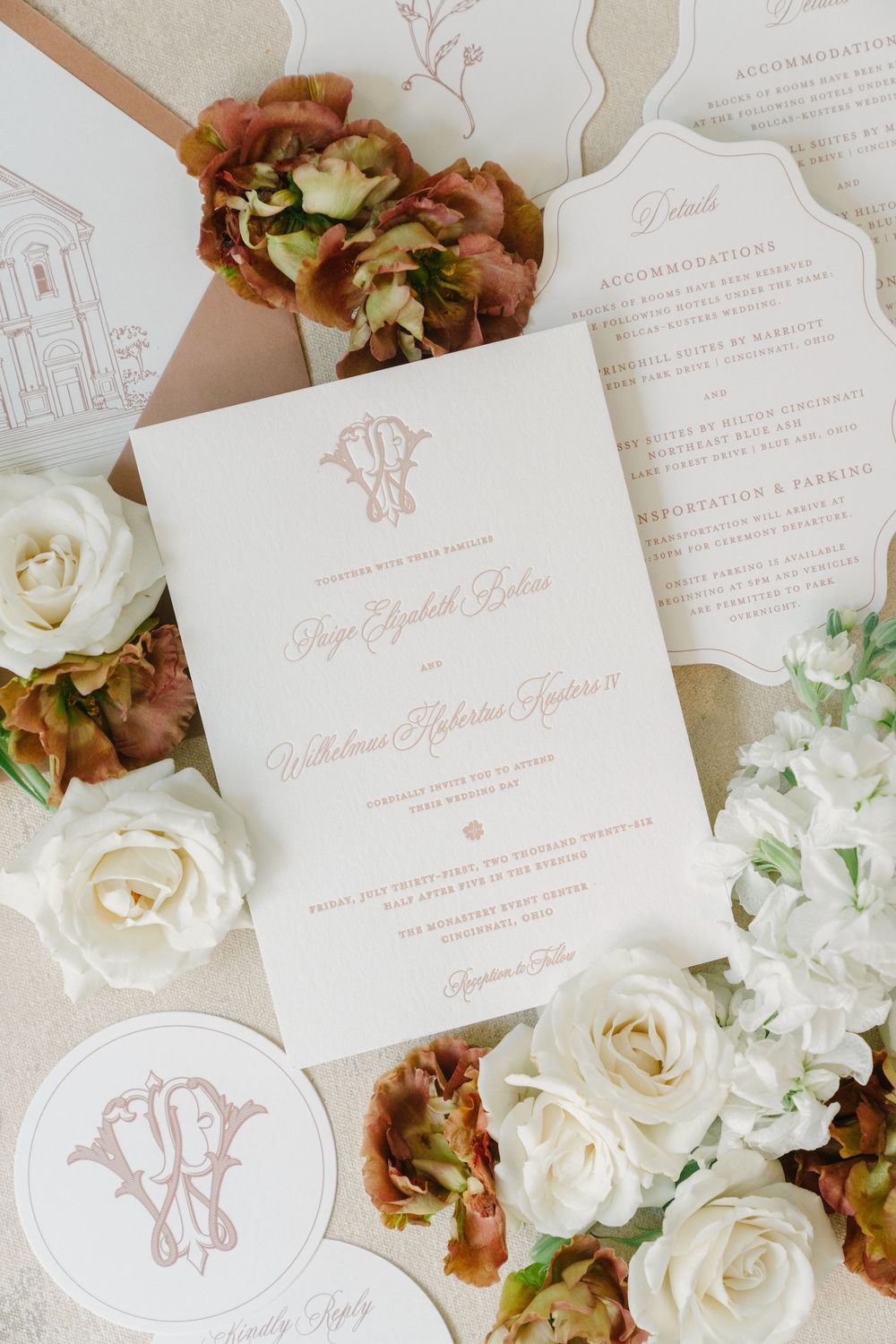 Elegant wedding invitation suite with monogram, white roses, and dried florals in blush and gold tones.