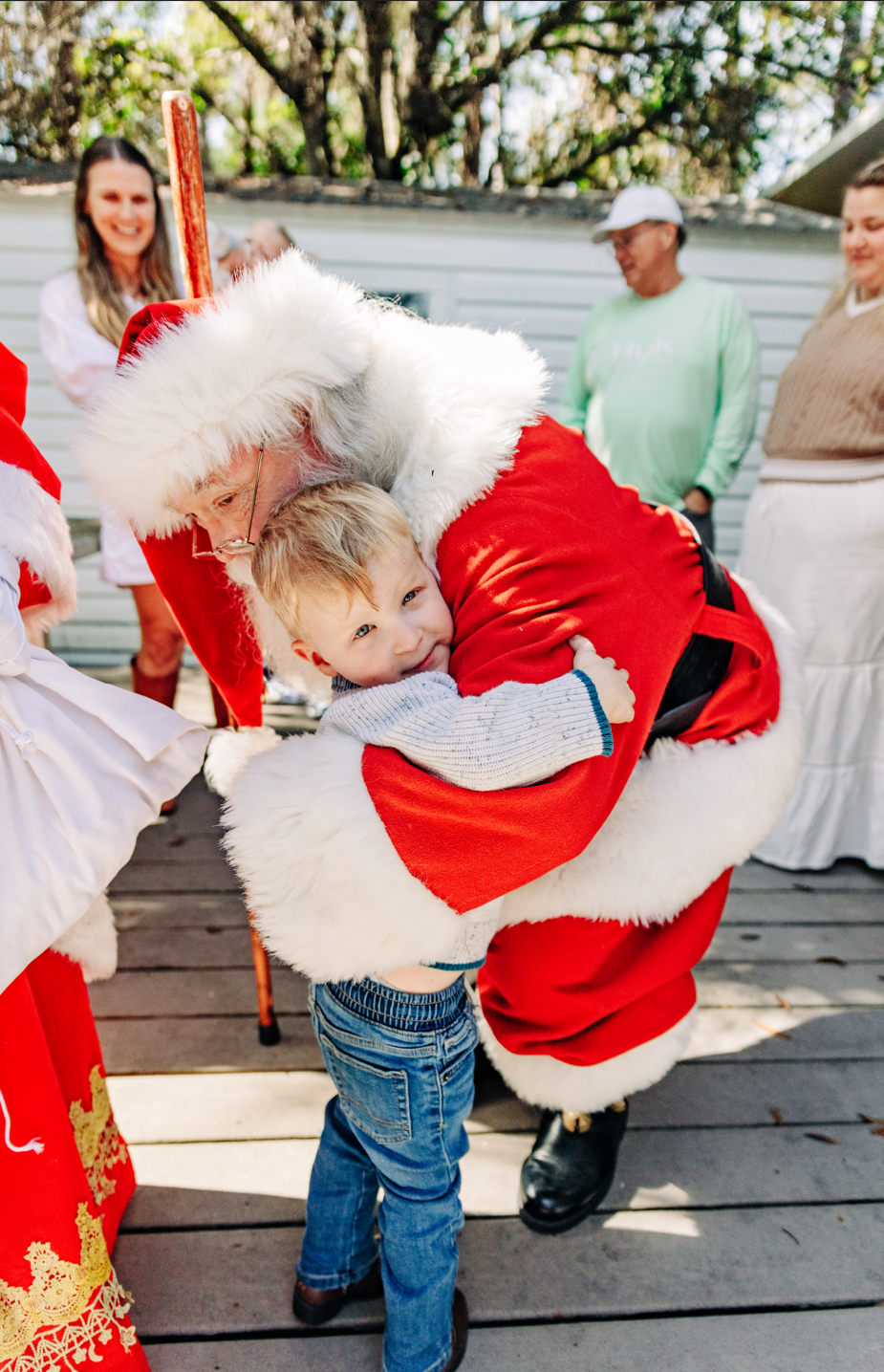 Santa photos in Lake Worth Beach of a young boy hugging Santa Claus during a Christmas experience.