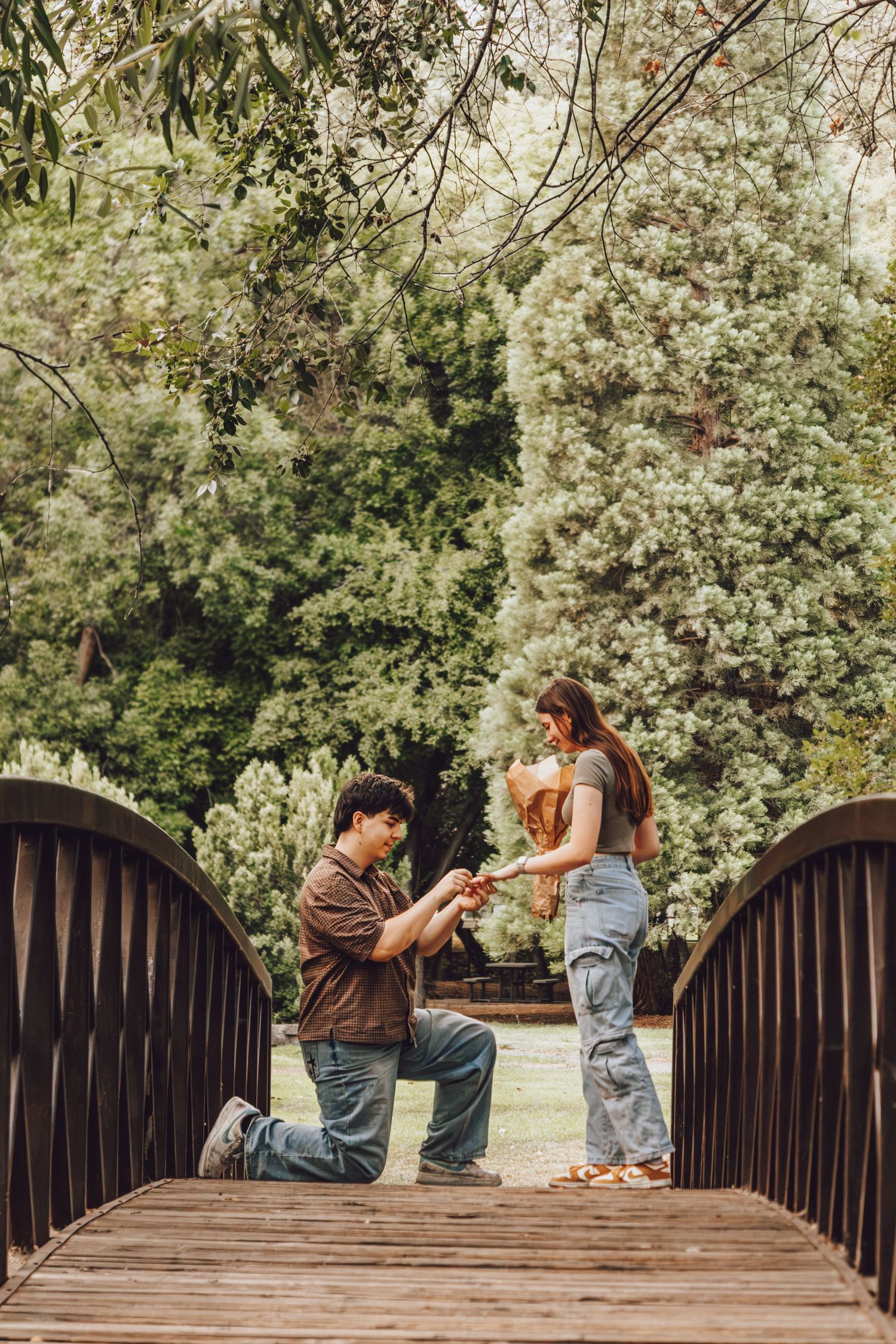 Man surprising his girlfriend with a proposal on a bridge in Provo, Utah