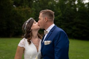 A couple in wedding attire sharing an intimate moment outdoors.