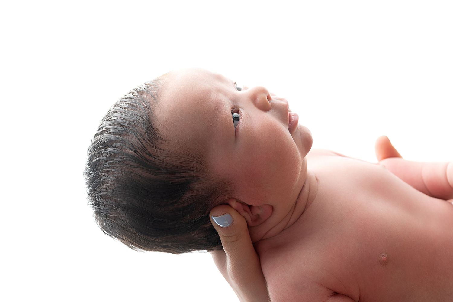 Newborn baby sleeping peacefully in soft natural light.