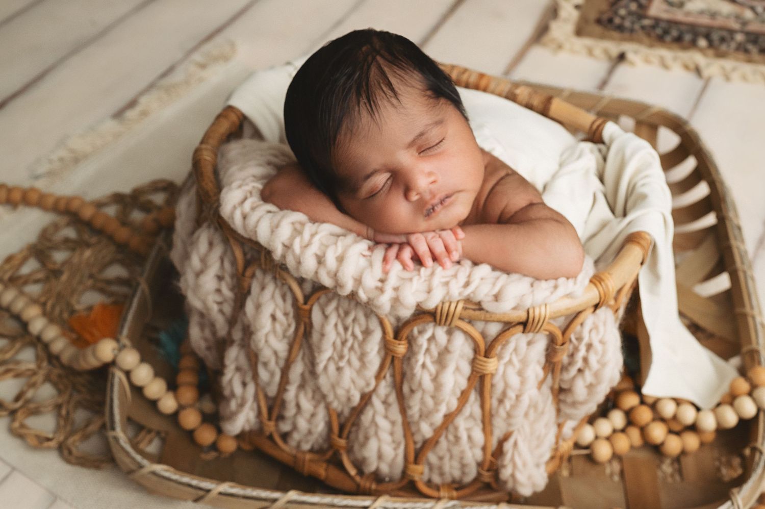 Peaceful sleeping newborn in knitted wrap nestled in vintage basket.