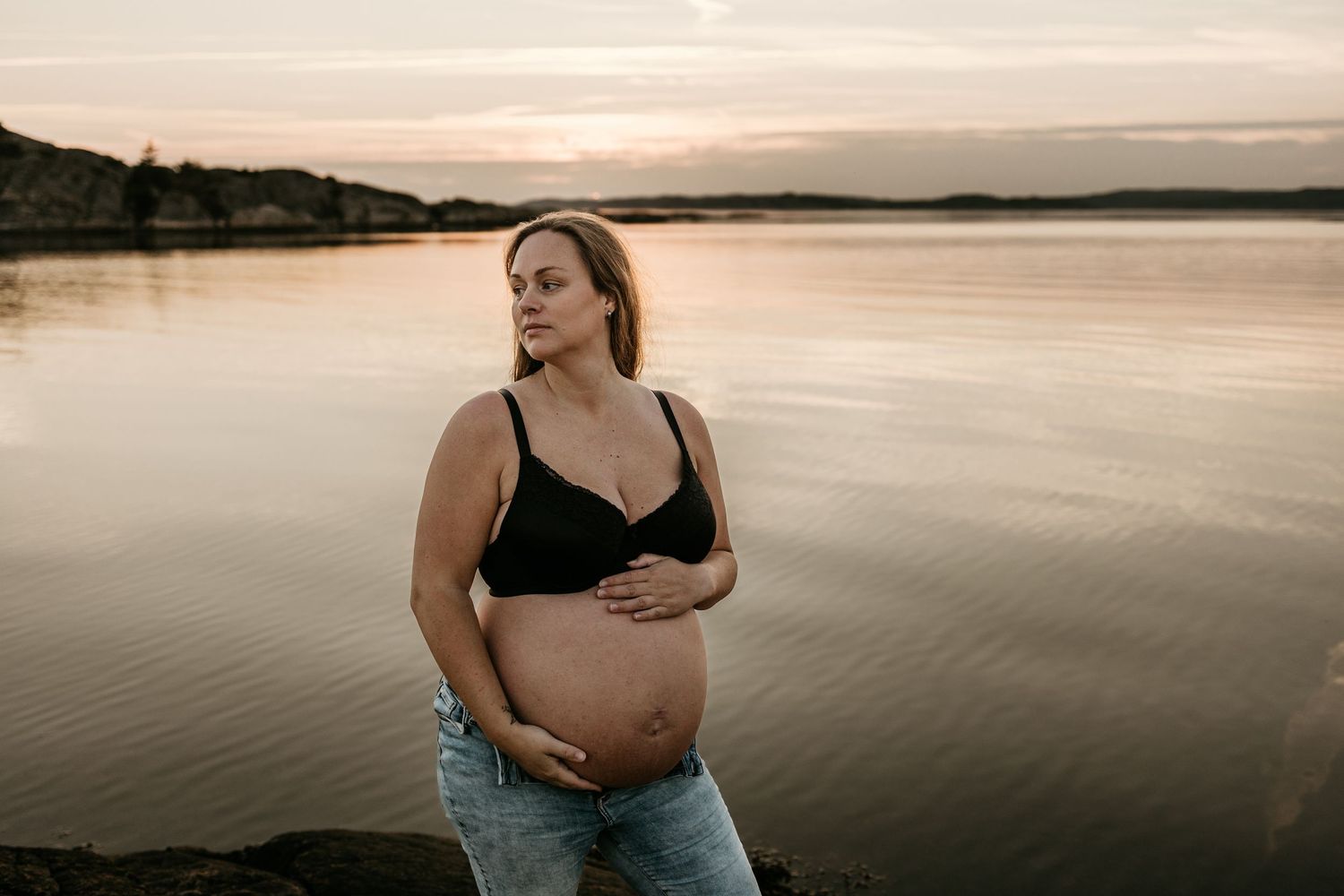Gravid kvinna i solnedgång på strand