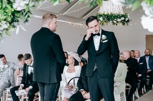 Wedding party enjoys candid moments during reception as they gather for casual black and white celebration photos.