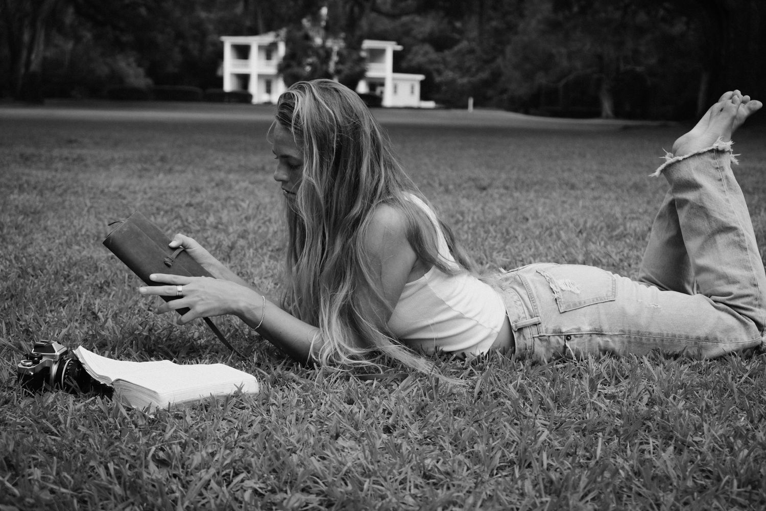 Black and white photo of people relaxing on grass in a park.