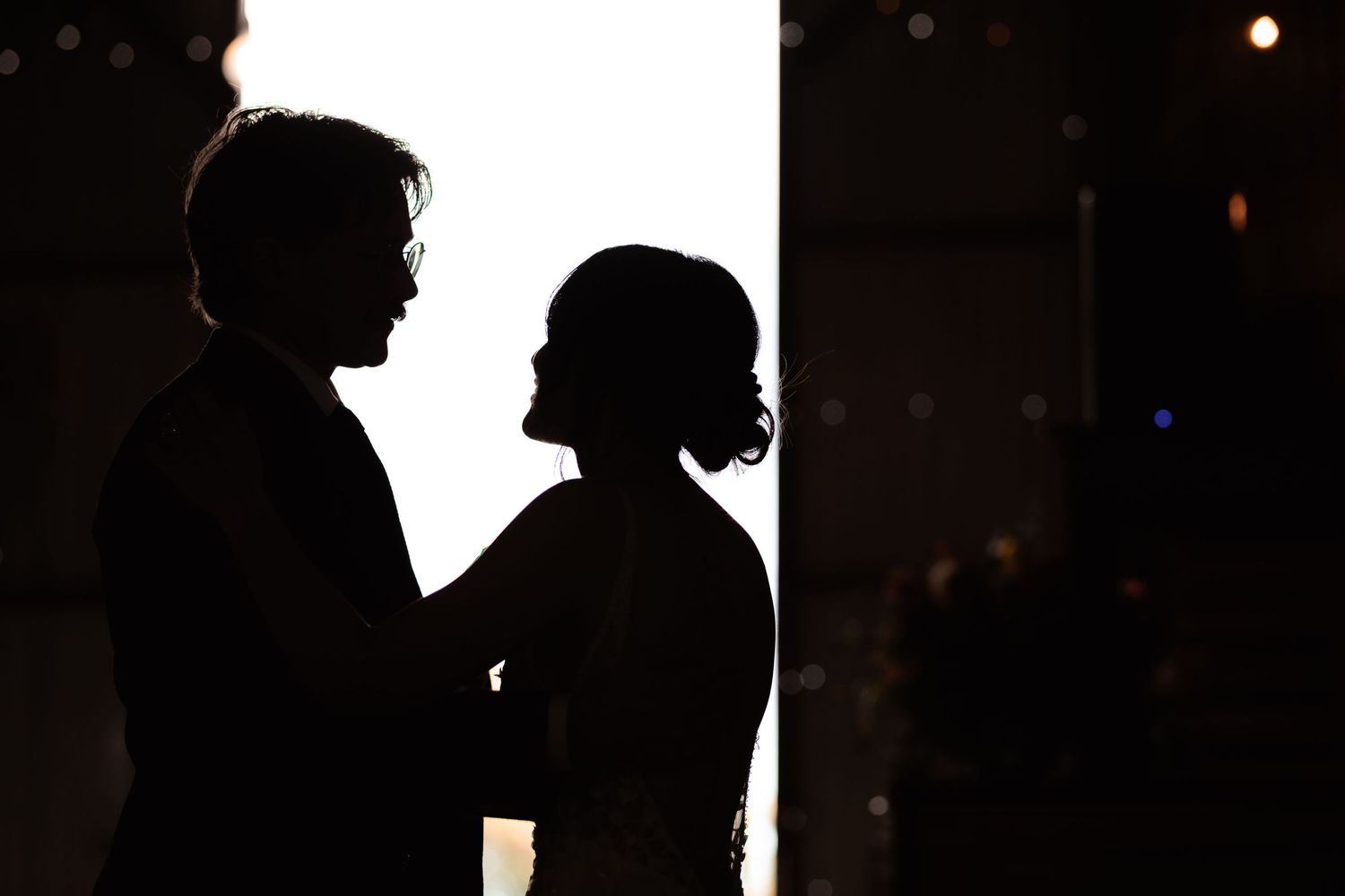 Dark silhouettes of people in profile against a bright background create a dramatic contrast effect.
