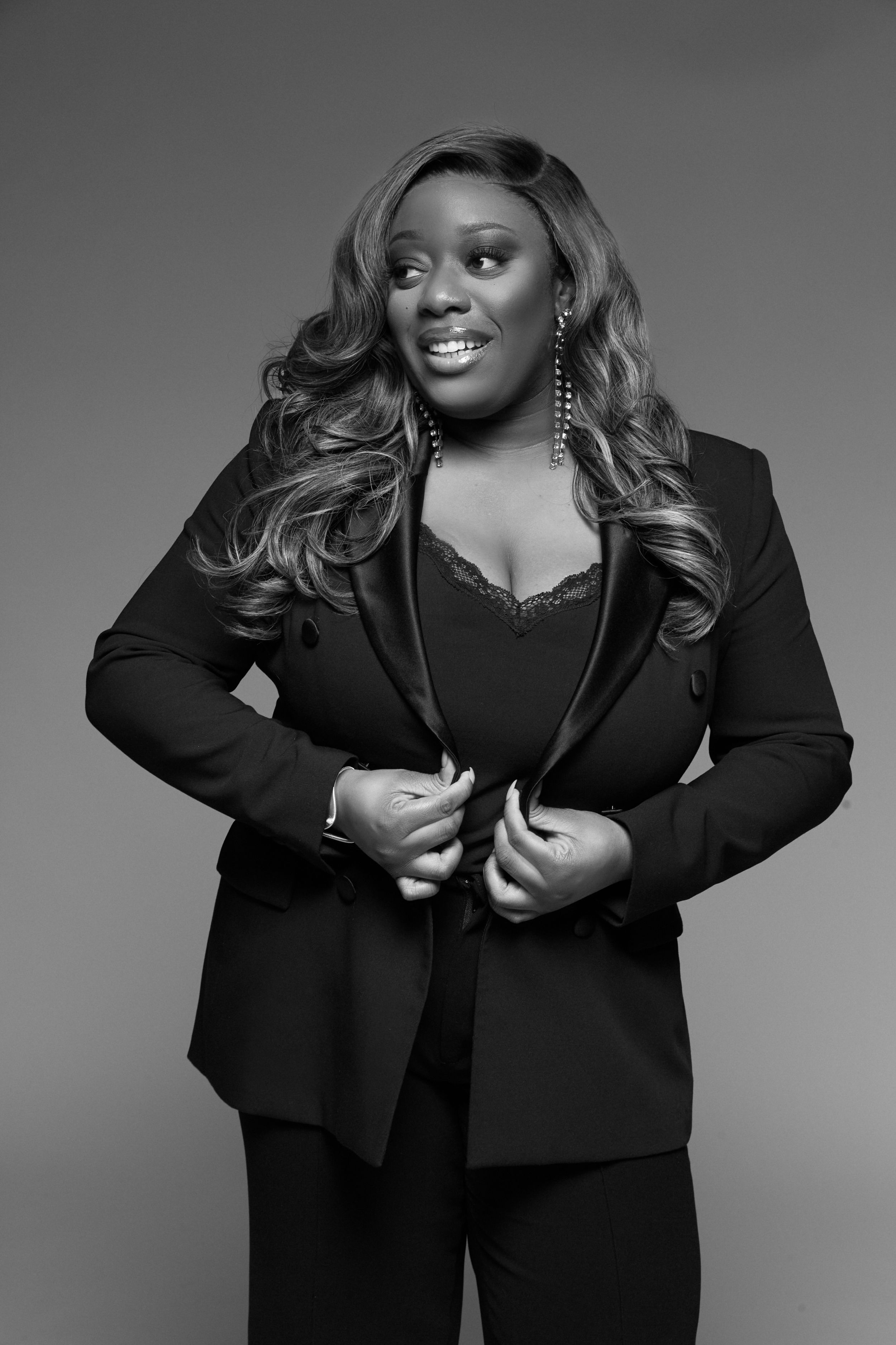 Professional studio portrait in black and white featuring elegant black business attire.