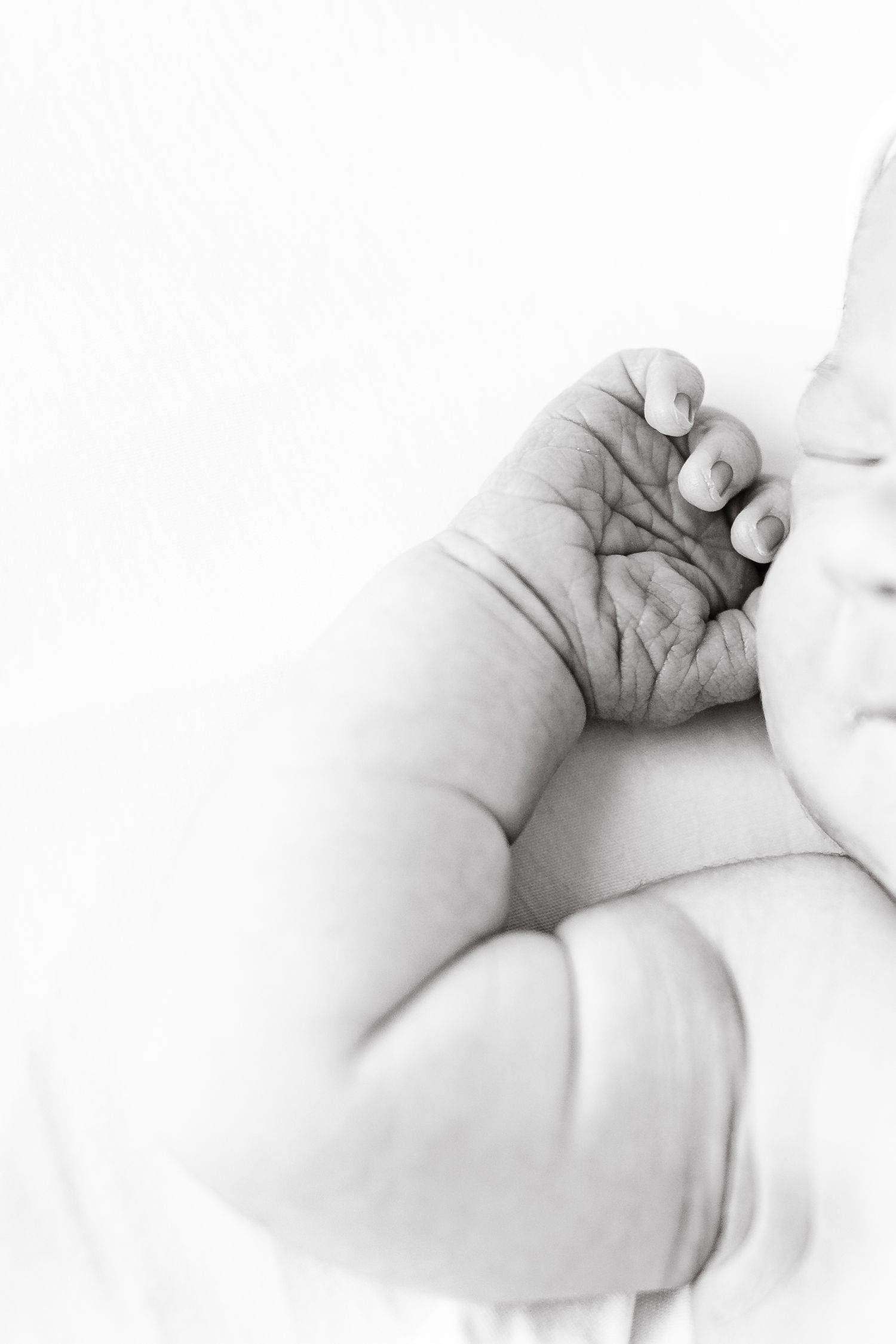 Tiny newborn feet with a special keepsake token resting between them.