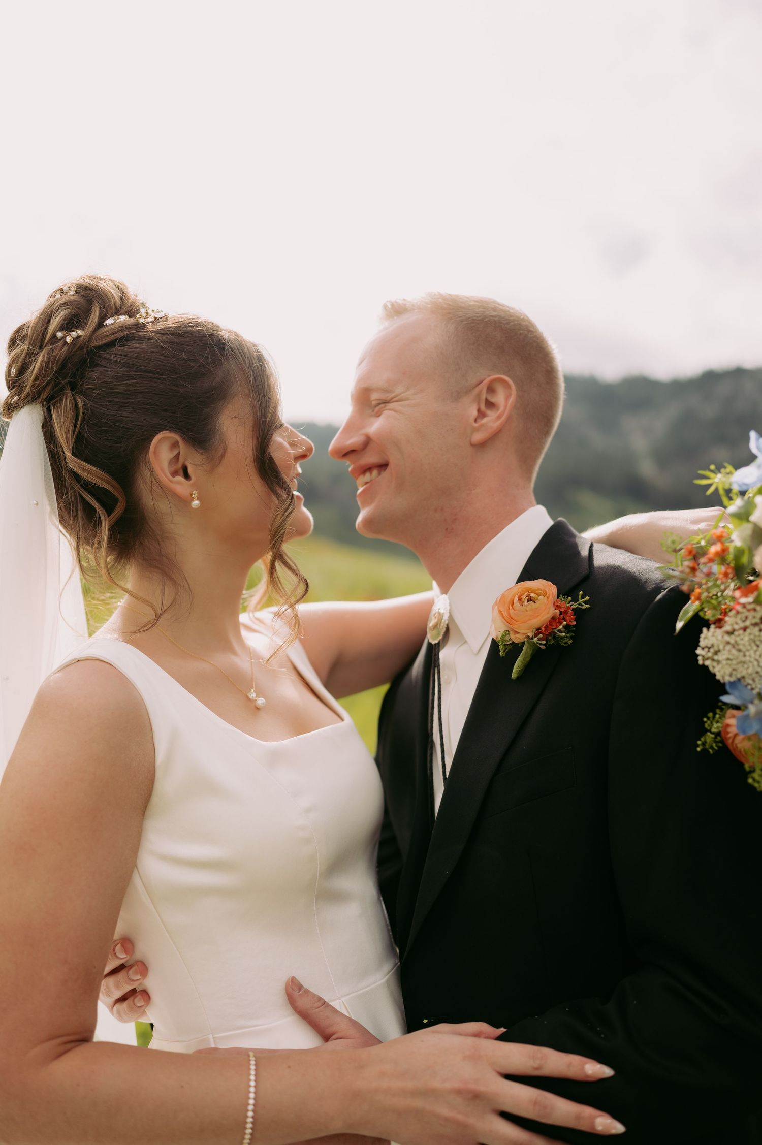 A joyful wedding moment captured between a couple in an outdoor setting.