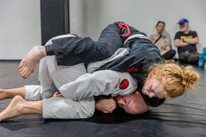 Jiu-jitsu practitioners demonstrating submission holds during a training session on the mat.