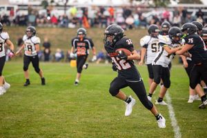 Football players lined up in formation on grass field during game action.