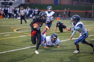 Youth football players in action making tackles and plays during competitive game.