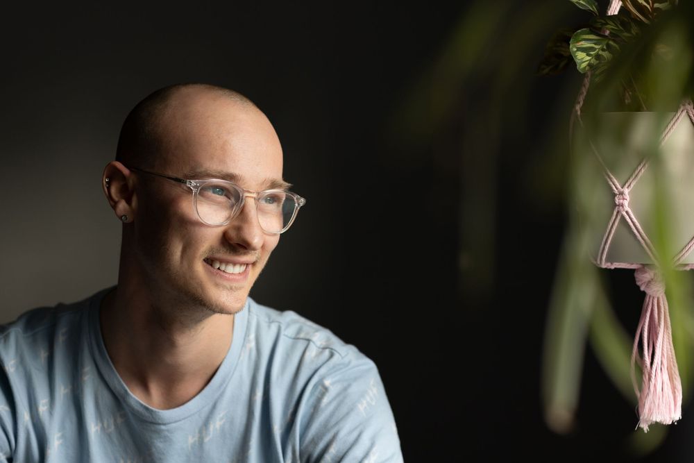 A series of casual portrait shots showing someone in a gray t-shirt and glasses against different backgrounds.