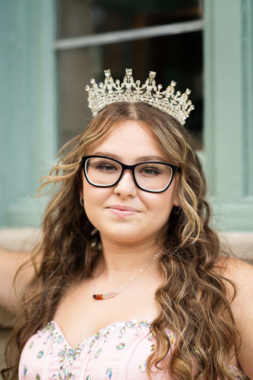 High school senior girl in a crown and ball gown laughing at Forest Park Jewel Box, St. Louis, MO during golden hour. Willow Run Photography