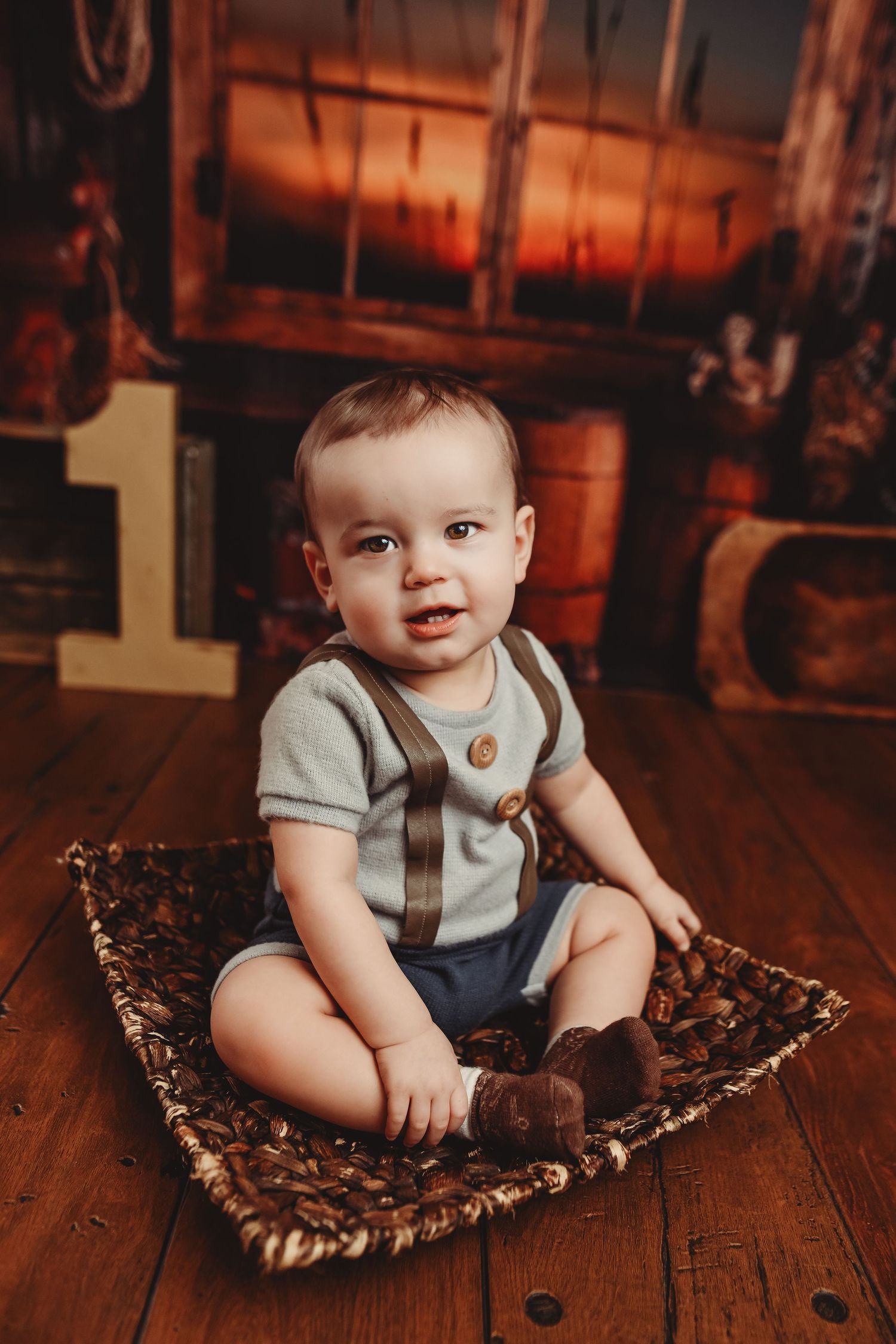 Vintage-style baby portrait on wooden floor with animal print blanket.