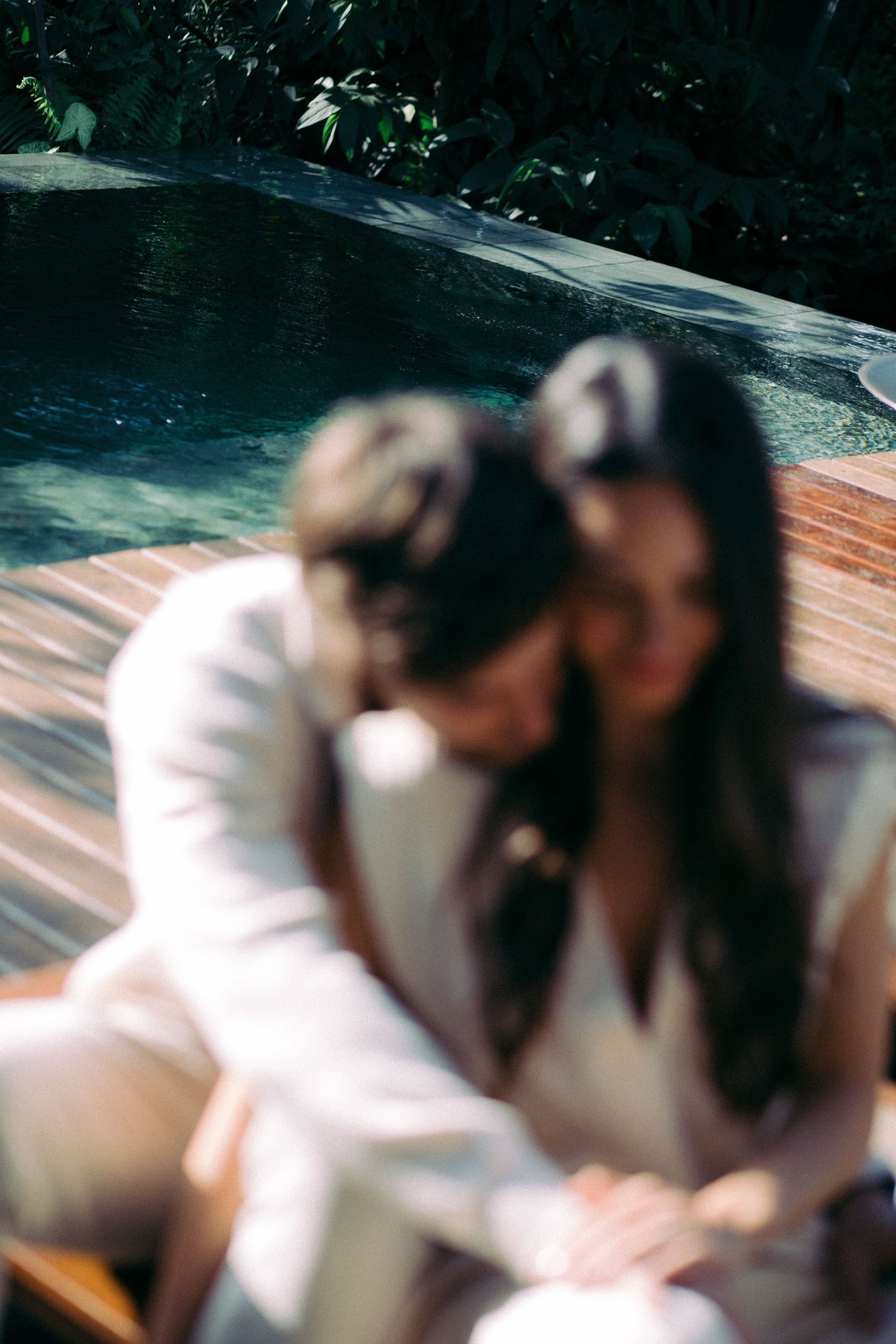 Motion blur photo of couple running together in white attire.