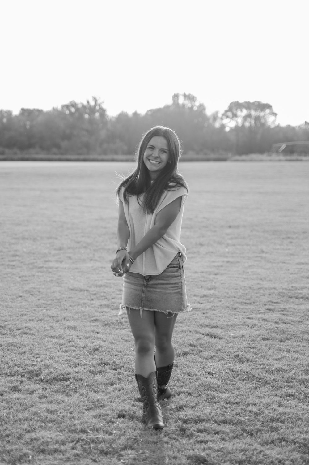 Black and white portrait of girl in field at sunset