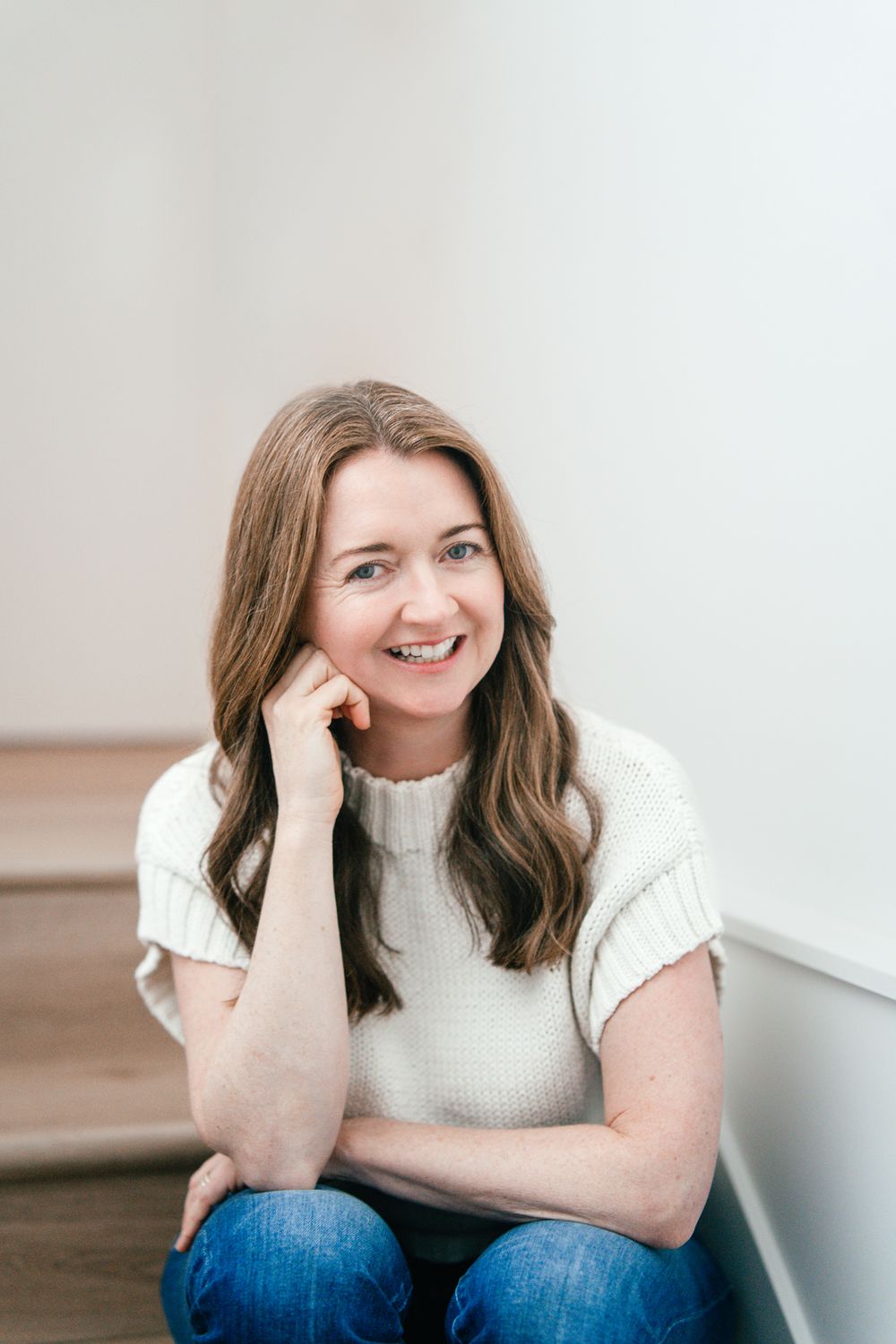 Woman sitting on the stairs in a white shirt headshot