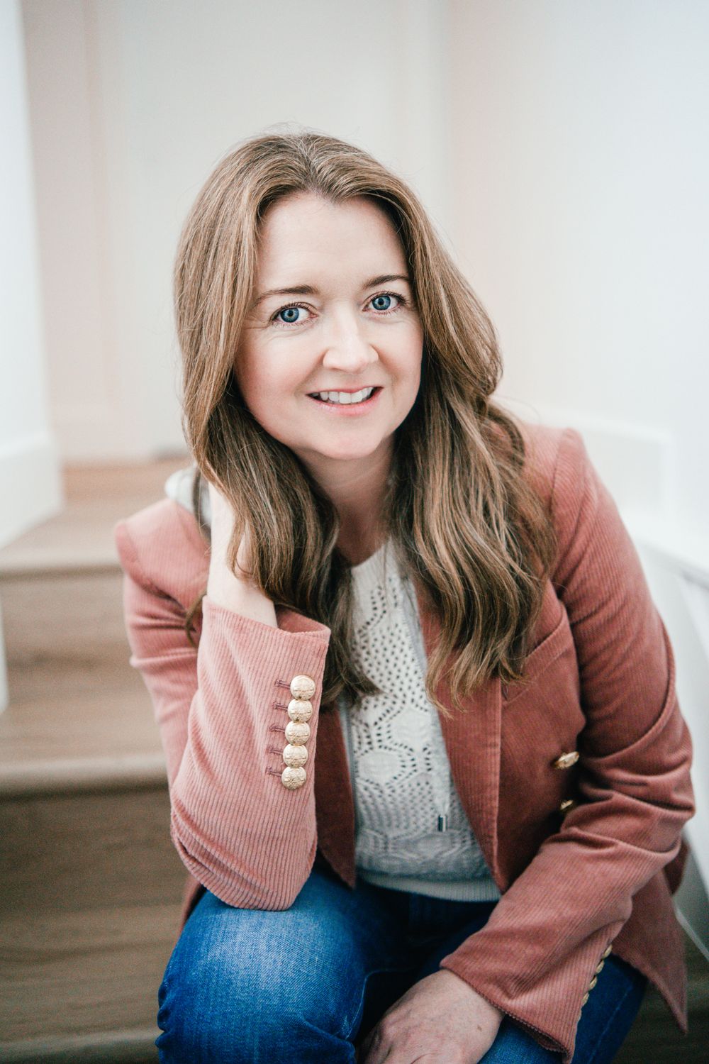 Women in a pink jacket sitting for a headshot