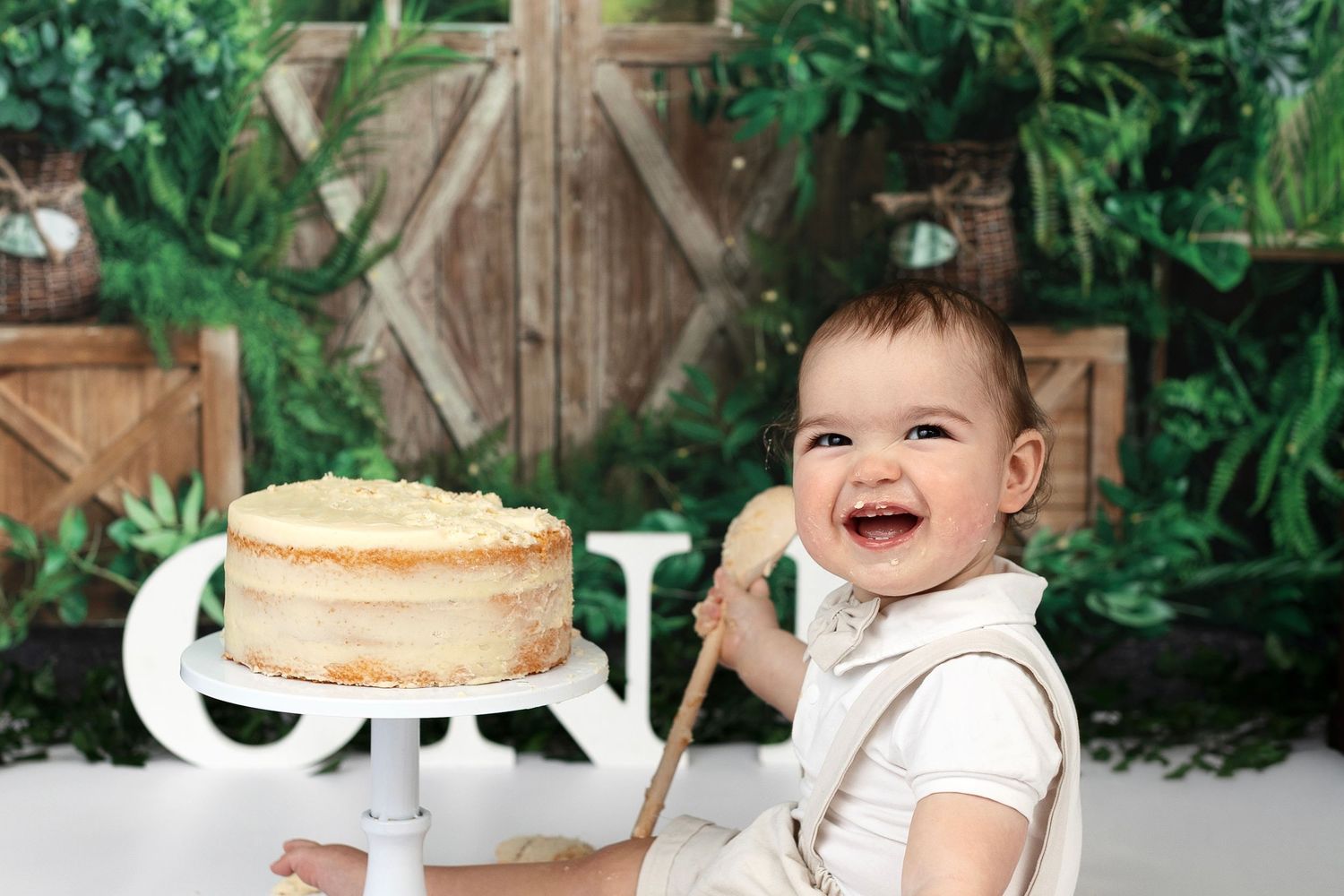 Pink cake smash setup with balloon arch and white ONE blocks for first birthday photo session.