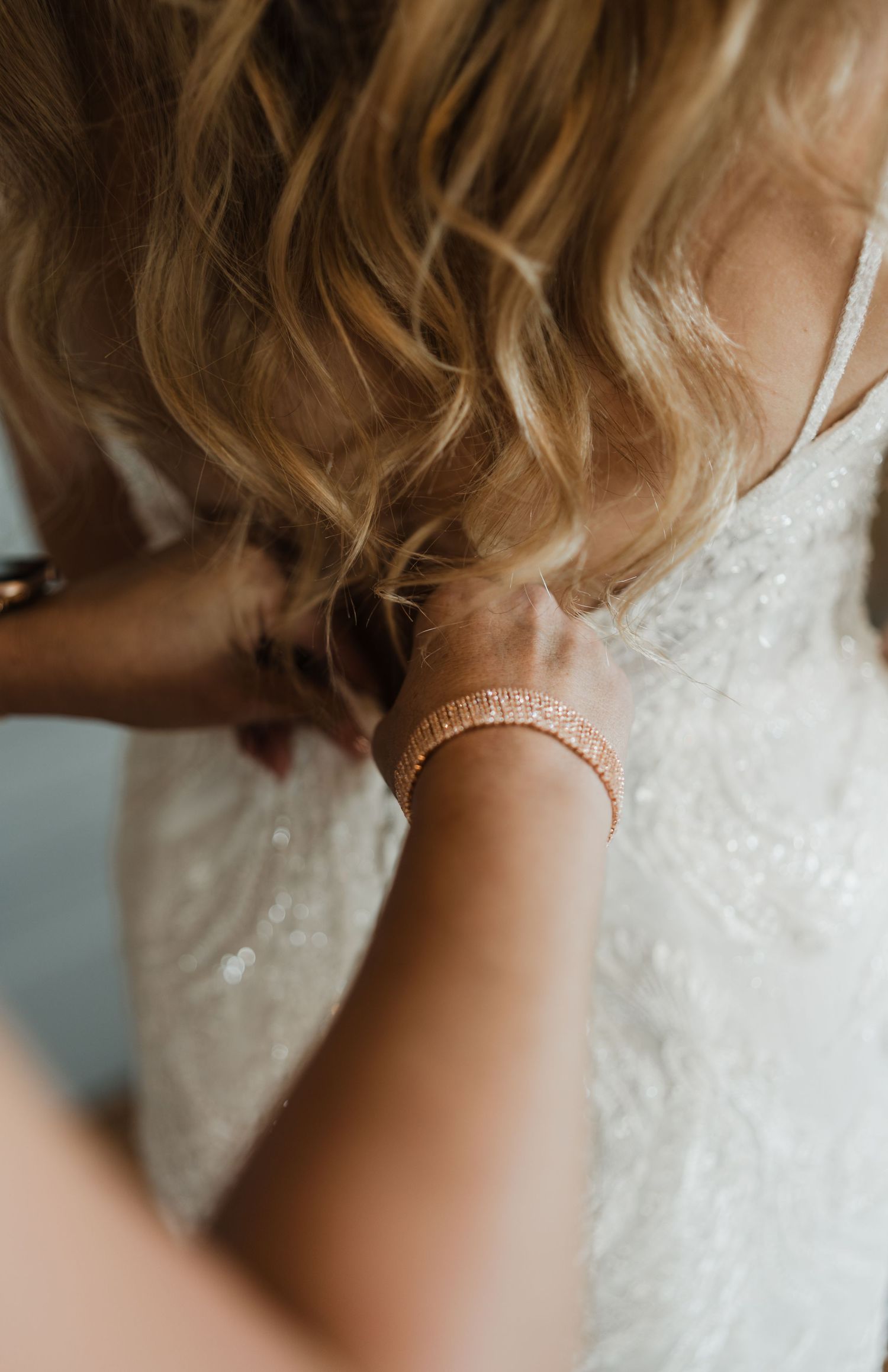 Delicate rose gold bracelets and jewelry details on a special occasion.