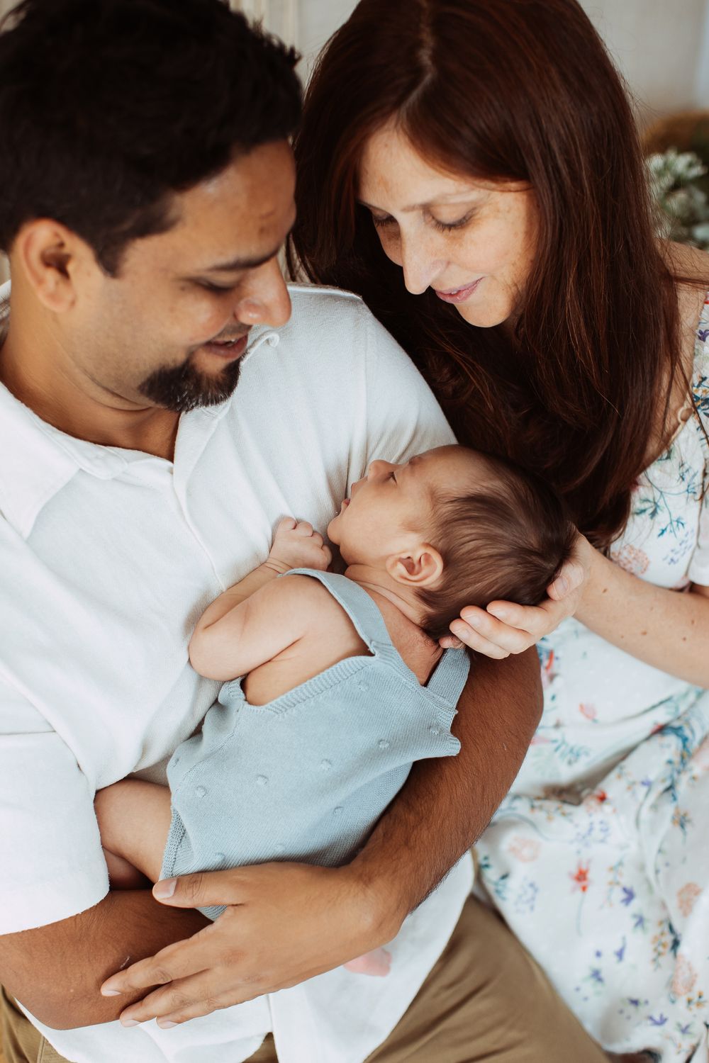 Parents sharing intimate bonding moment with their newborn baby.